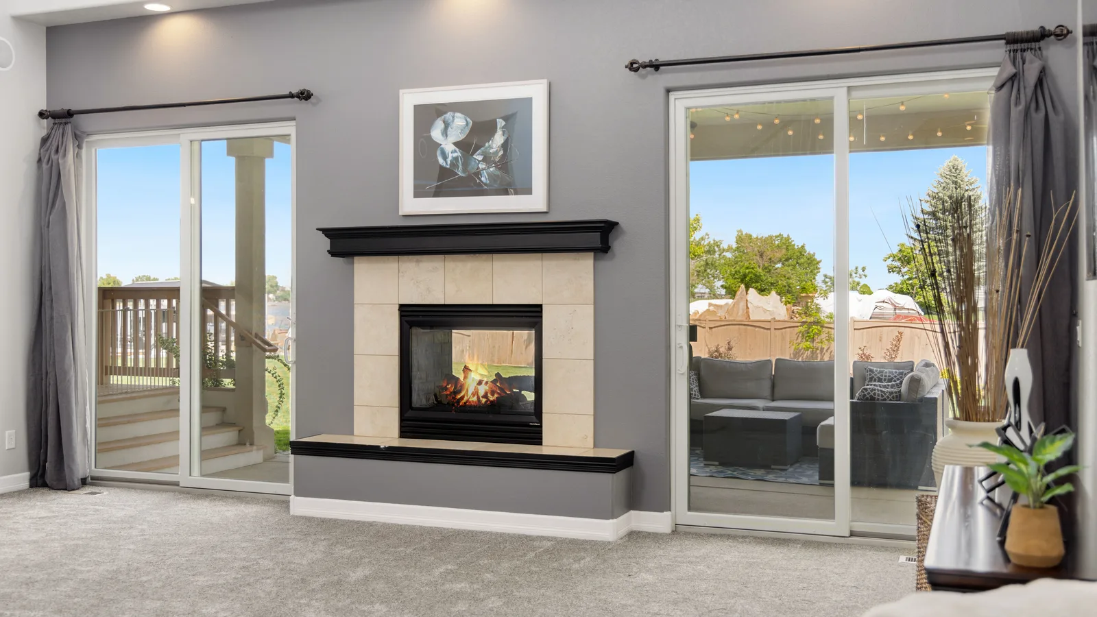 Two closed sliding glass door assemblies beside a fireplace